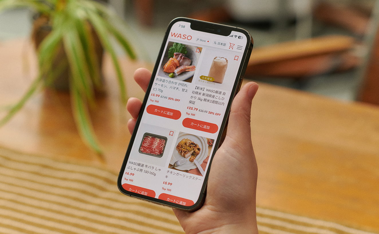 WASOのオンラインストアを表示したスマートフォンを持つ手の写真