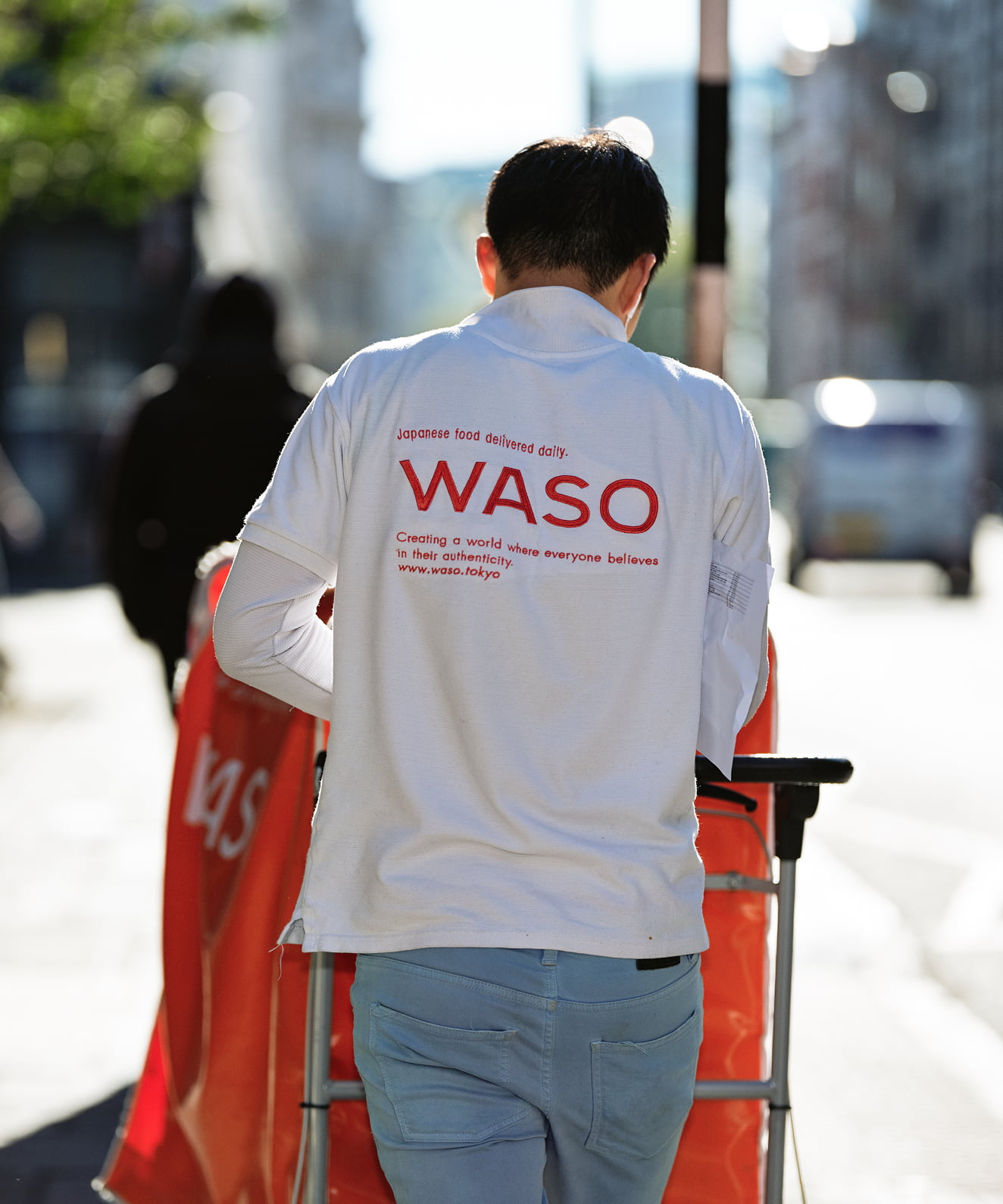 街中でカートを押すWASOの配達スタッフの写真
